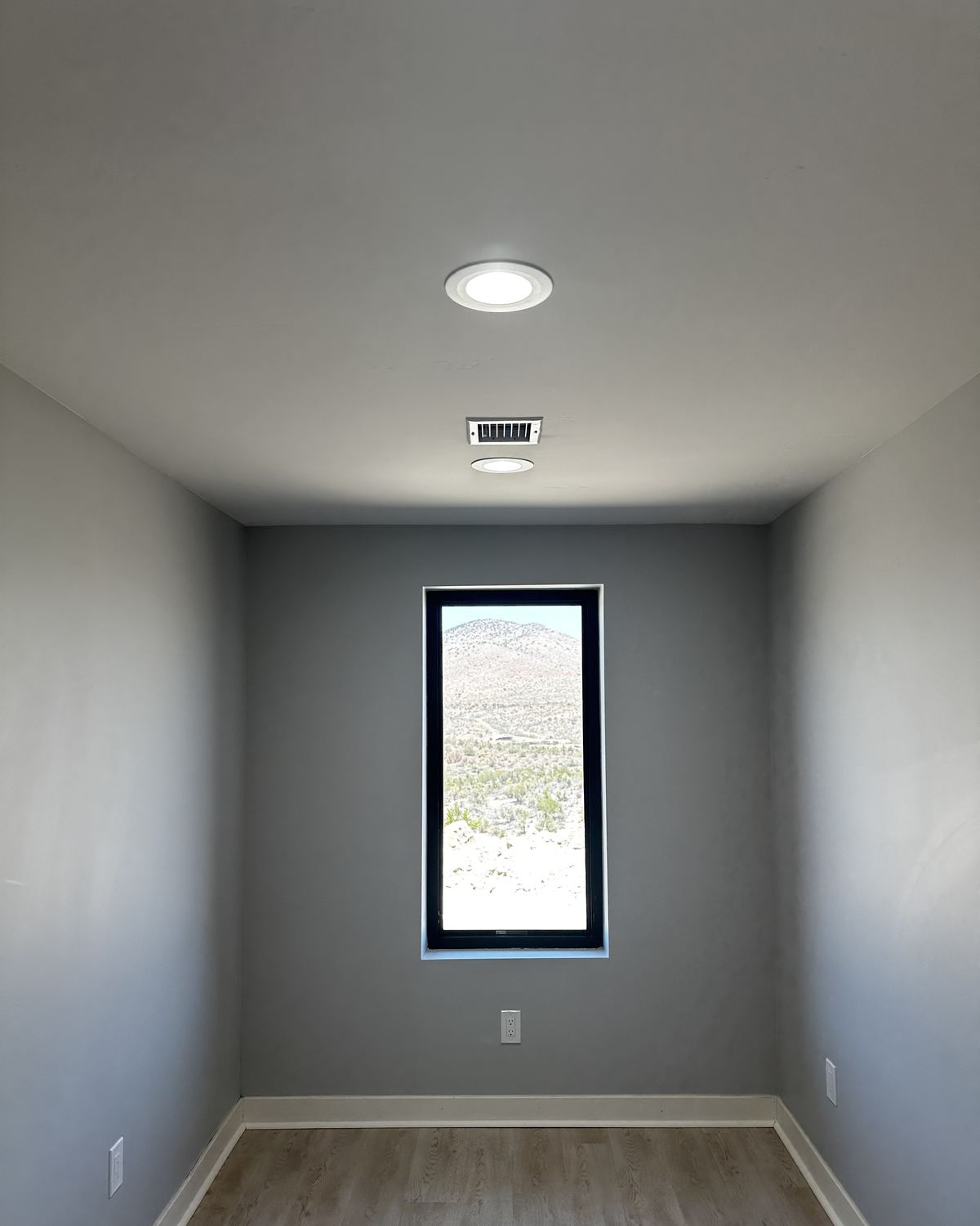 Recessed LED downlights in the ceiling of a finished room, with a dimmer on the wall.
